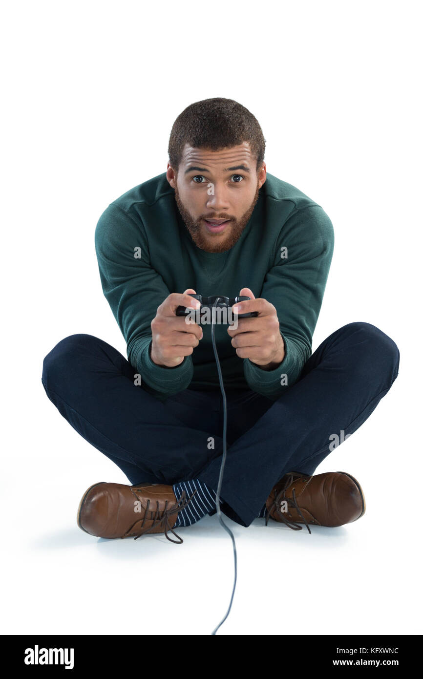 Aufmerksamen Mann spielt Video Spiel gegen weißen Hintergrund Stockfoto