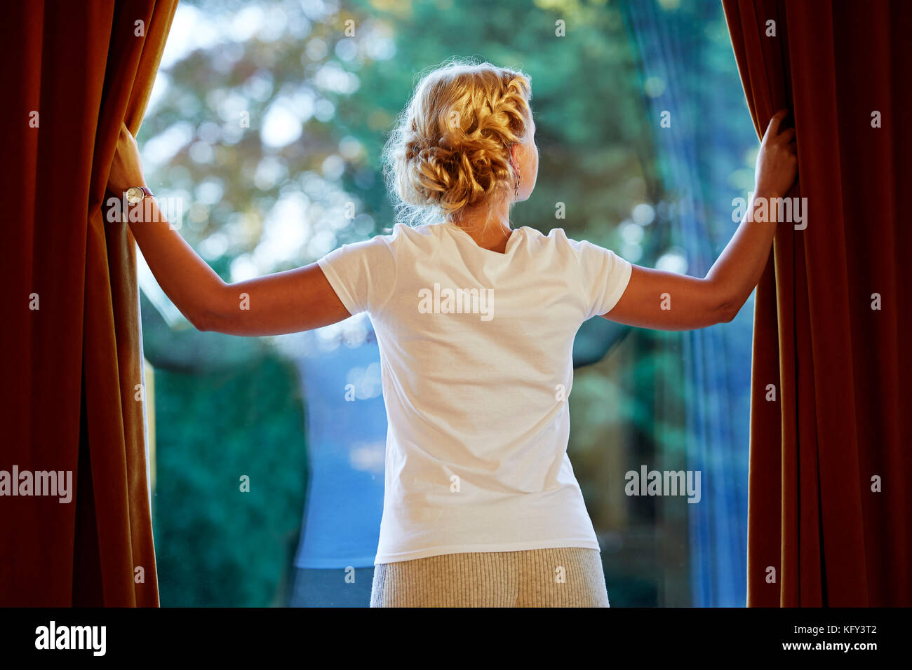 Frau Eröffnung Vorhänge Stockfoto