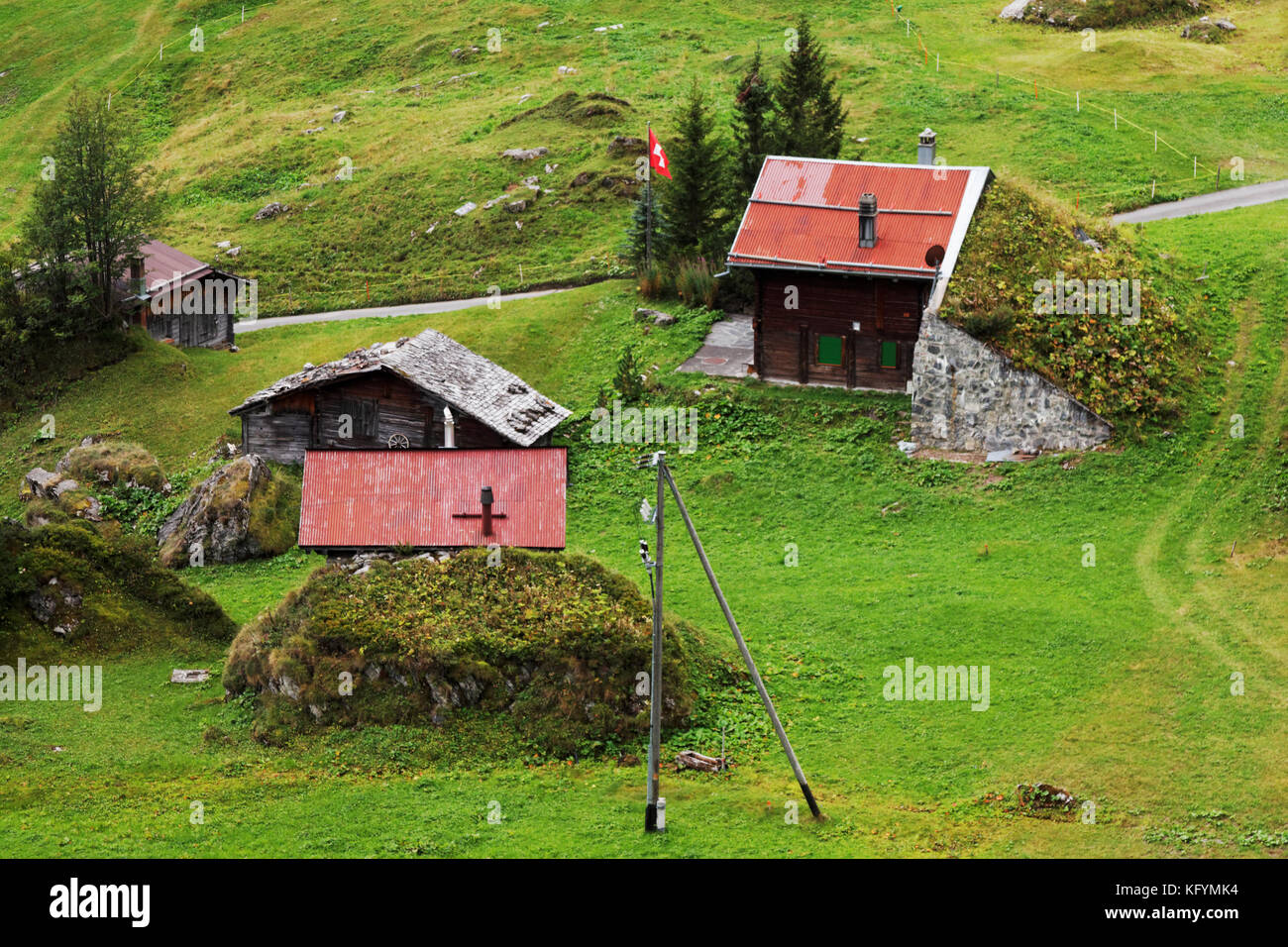 Durch Steinbarrieren vor Lawinen geschützte Gebäude im Schweizer Bergdorf Schiltalp, Berner Oberland, Schweiz Stockfoto