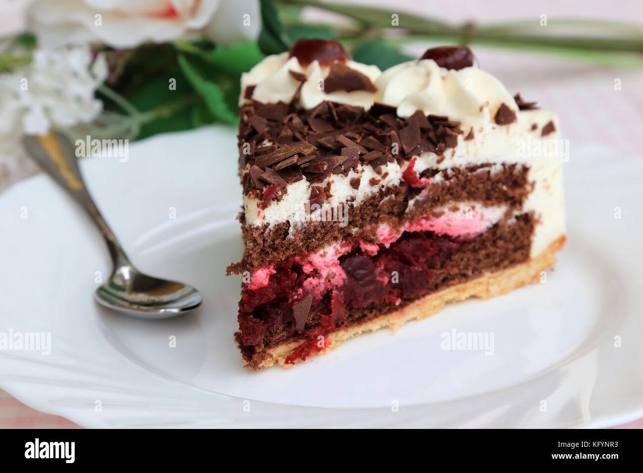 Schwarzwälder Kirschtorte auf die weiße Platte mit Blumen Stockfoto