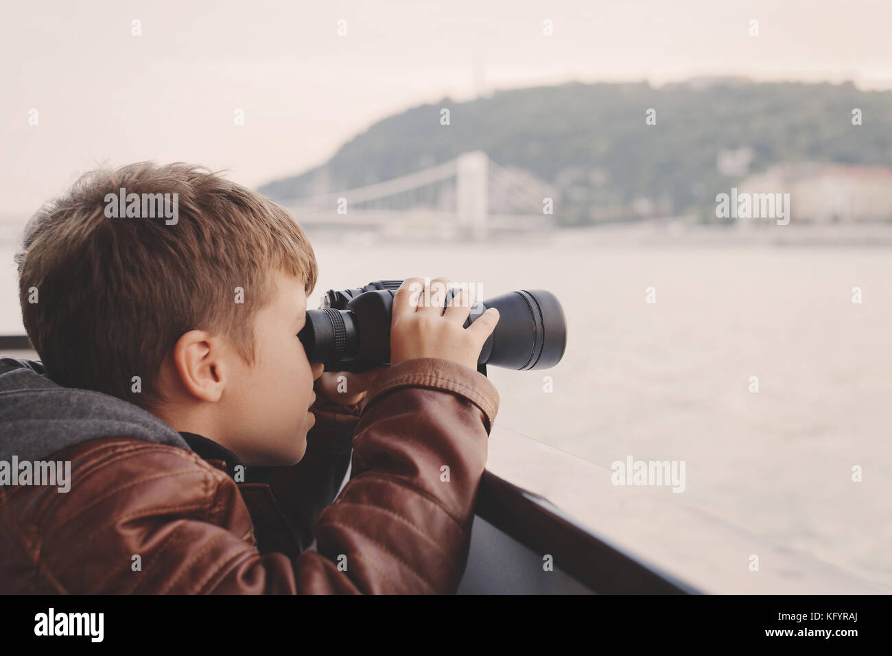 Wenig kaukasischen Jungen mit Fernglas während der Reise auf der Donau, Budapest, Ungarn Stockfoto