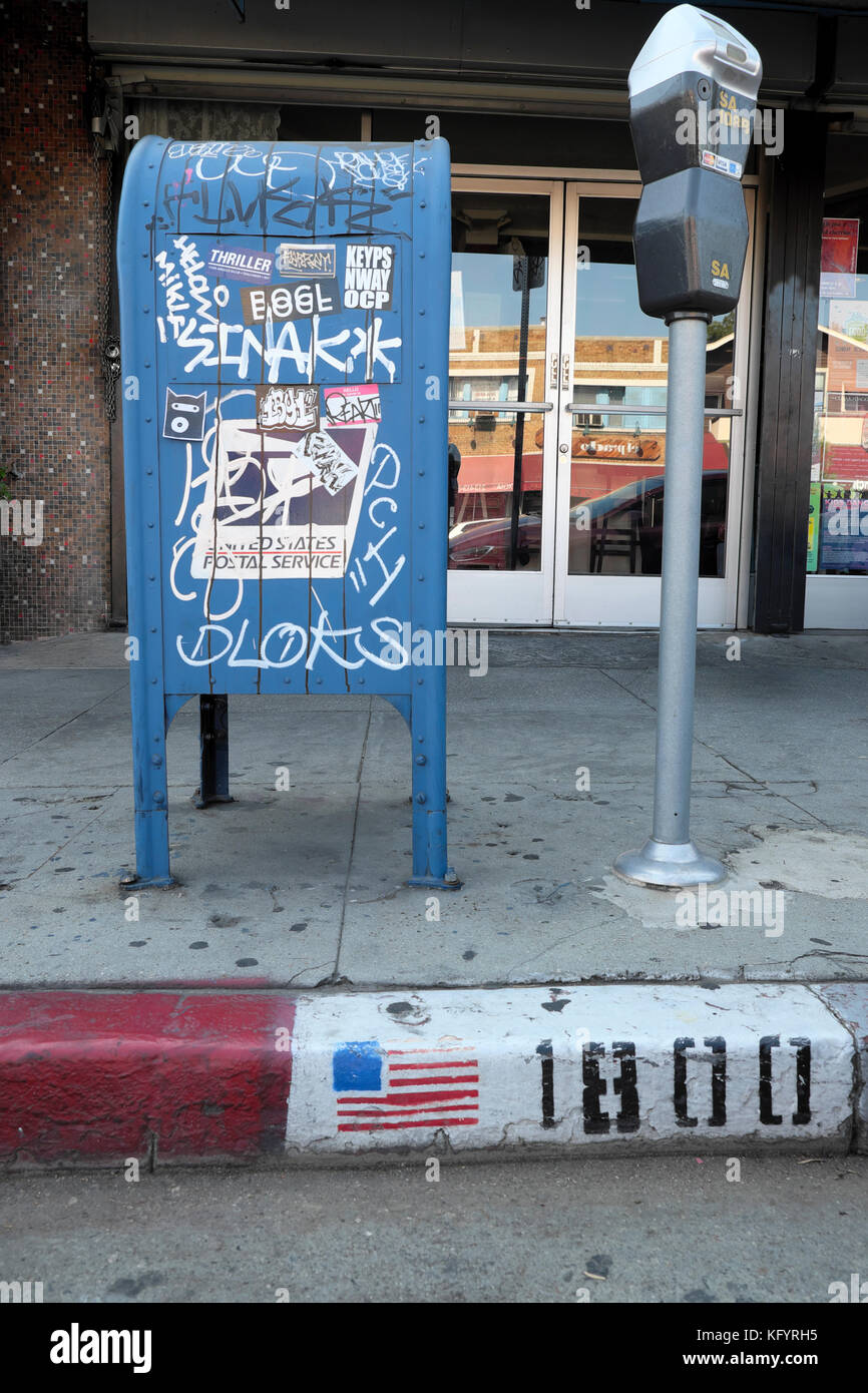 Graffiti auf der Mailbox neben Parkuhr mit amerikanischer Flagge auf dem Bordstein auf dem Sunset Blvd, Echo Park, Los Angeles, Kalifornien, USA KATHY DEWITT Stockfoto