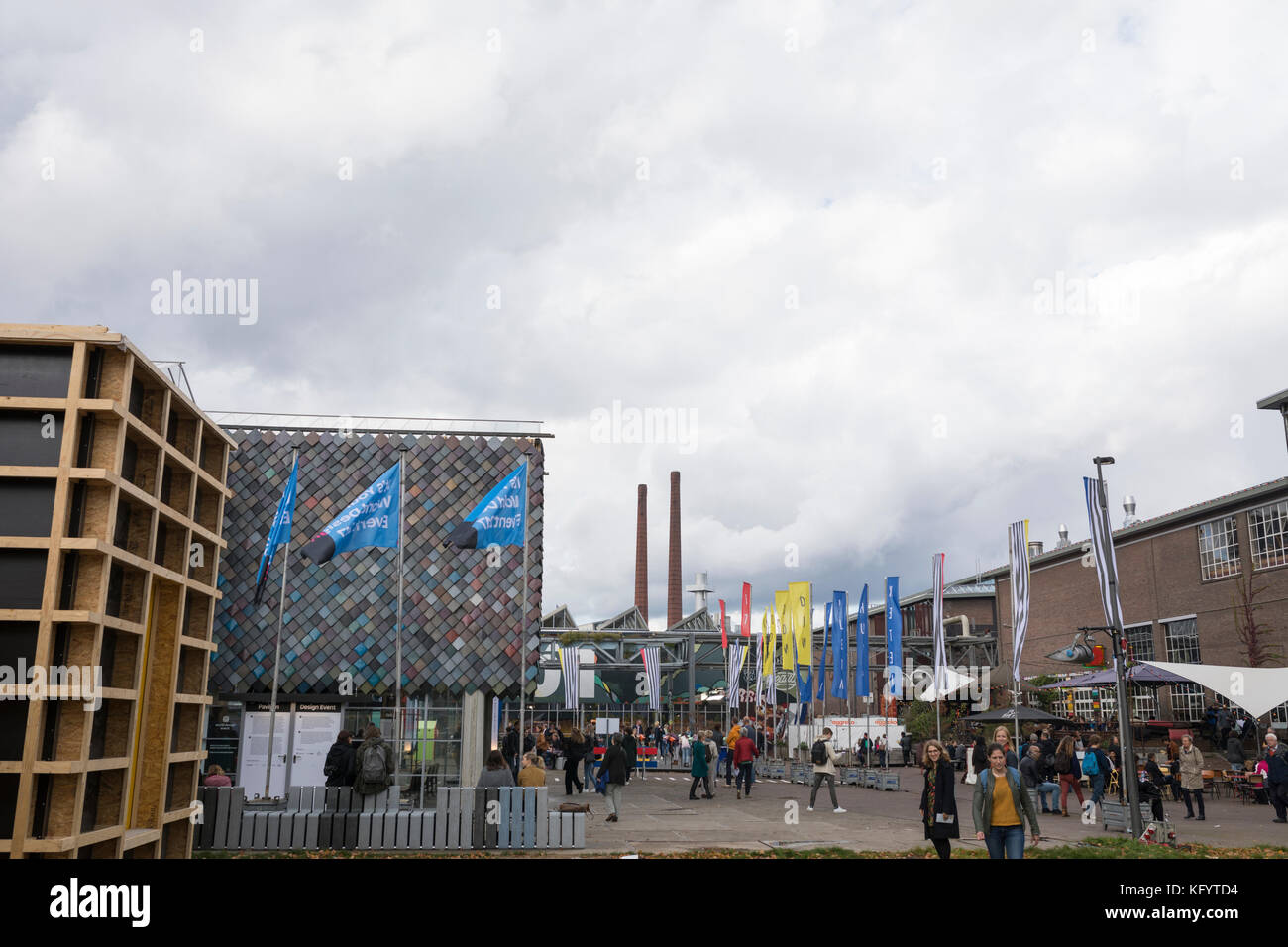 Besucher, die bei der Dutch Design Week, Niederlande, Eindhoven, von einem Gebäude zum anderen im Freien spazieren Stockfoto