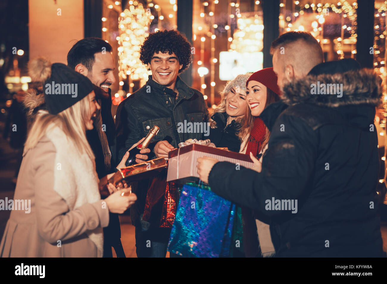 Sechs schöne junge Menschen Spaß beim Kauf einige Geschenke und lächelnd halten viele shopping Tüten und Schachteln in der Stadt Straße. Stockfoto