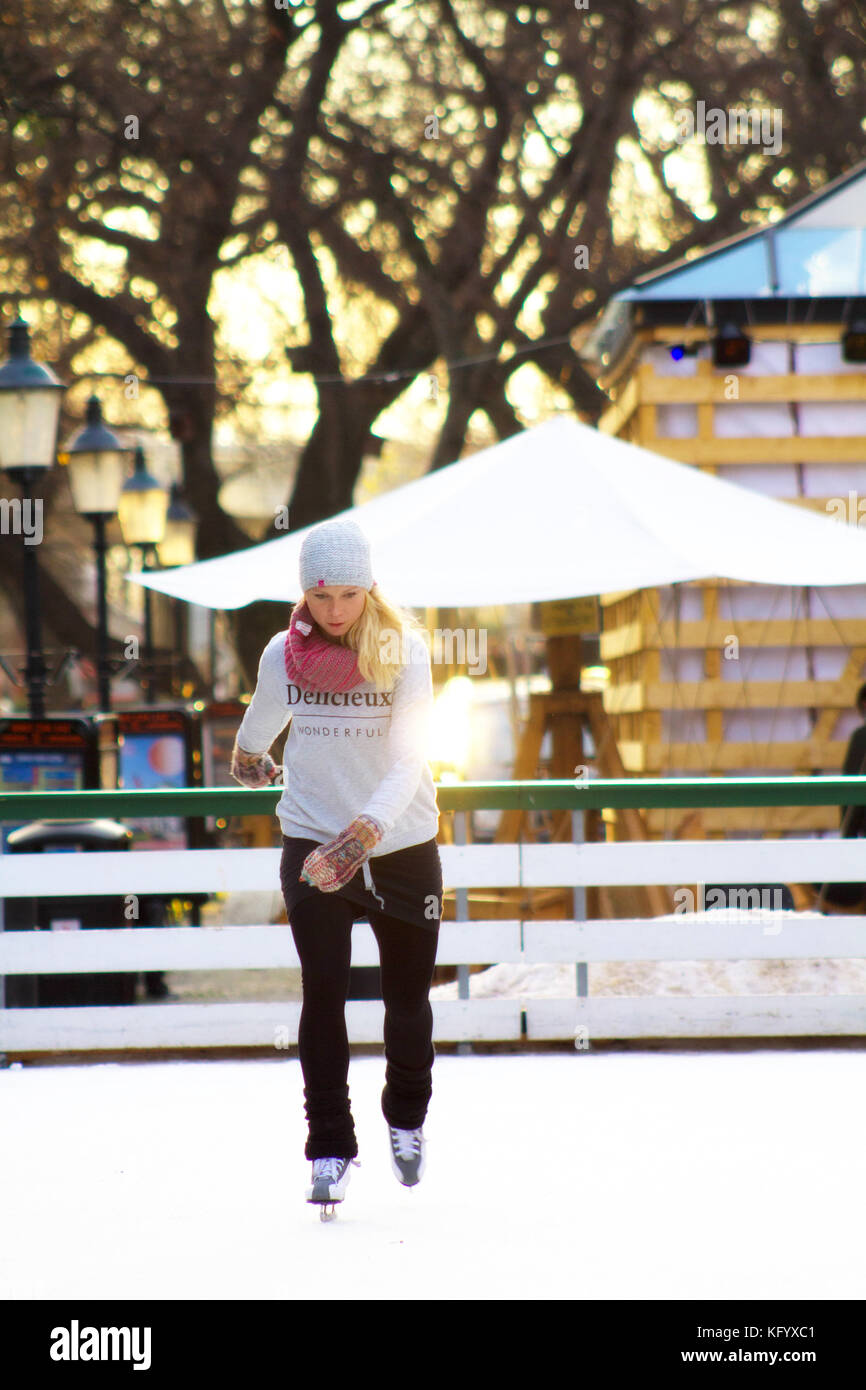 Eine junge Frau Schlittschuhlaufen auf der Eisbahn im Freien. Stockfoto