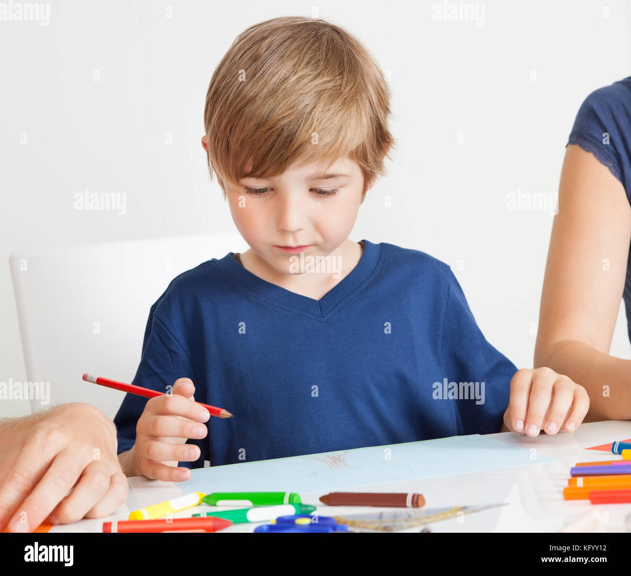 Kleiner Junge zusammen mit bunten Bleistiften zu Hause zeichnen Stockfoto