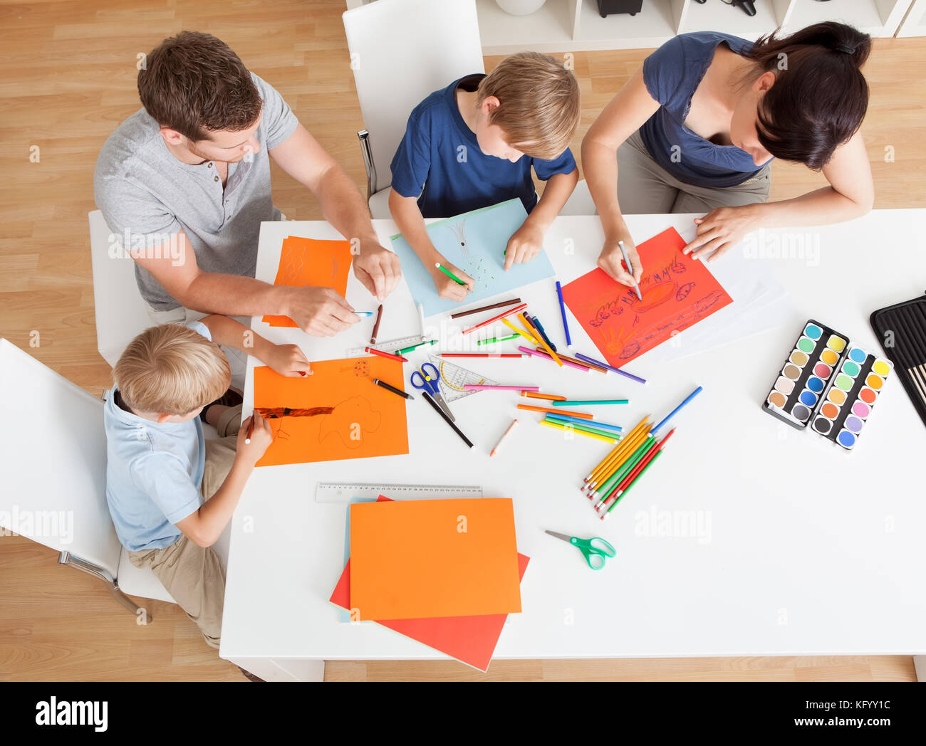 Junge Familie zeichnen zusammen mit bunten Bleistiften zu Hause Stockfoto