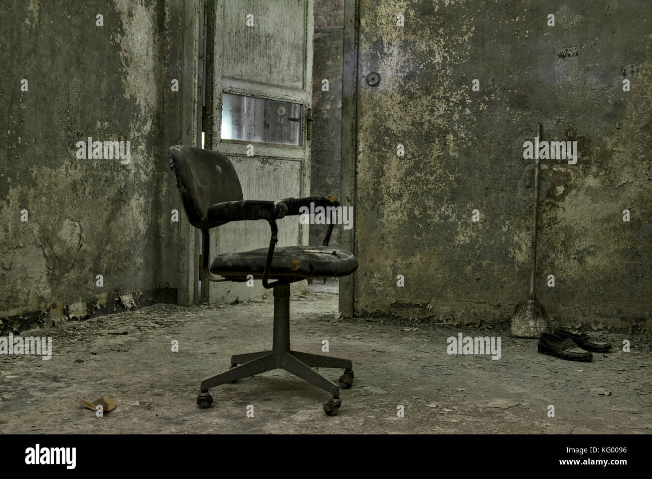 Ein furchtsames geschossen von einem Stuhl in der Dunkelheit, in einem Raum eines verlassenen psychiatrischen Krankenhaus, mit einem unheimlichen Umgebung. Stockfoto