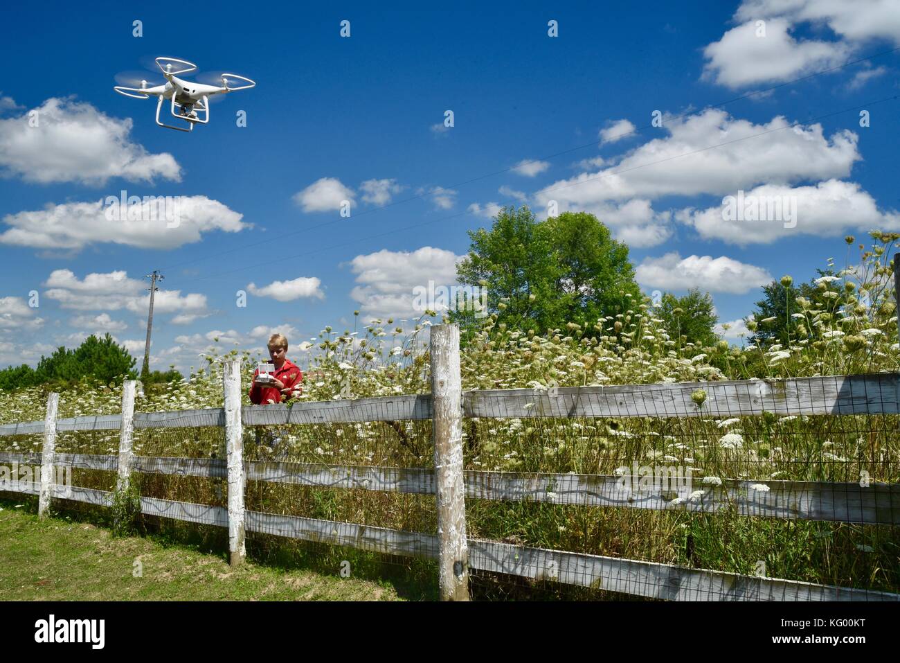 Jugendlich junge Fliegen dji Phantom 4 Pro+ Drohne zu prüfen Fechten auf ländlichen Bauernhof in den usa. Stockfoto