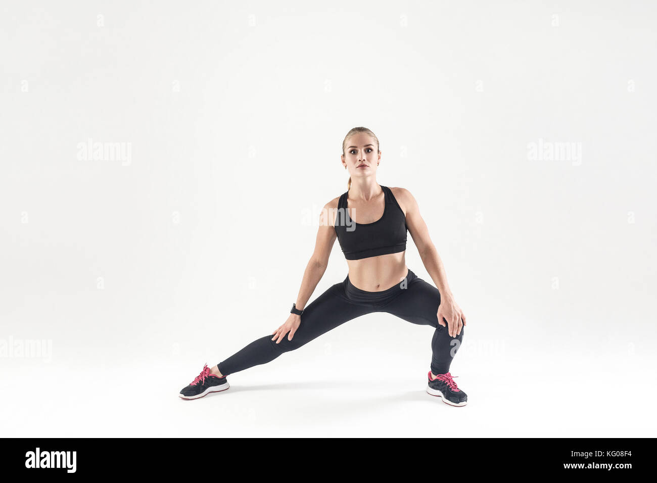 Woaman, Stretching und Kamera. Sportlich, Fitness Concept. studio Shot, grauer Hintergrund Stockfoto