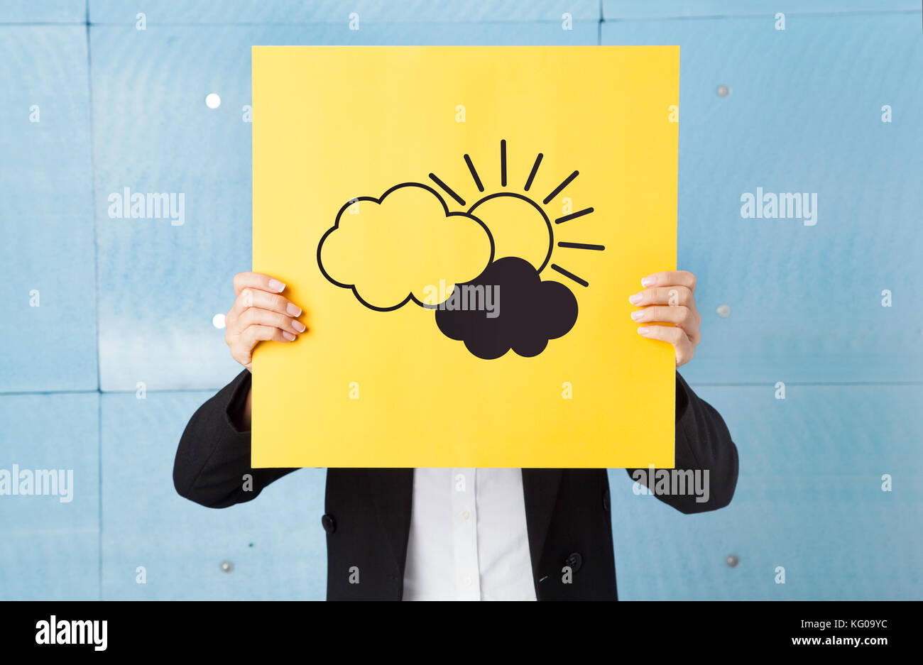 Junge Frau ihr Gesicht verstecken mit einem gelben Papier mit Wolken und Sonne auf sie Stockfoto