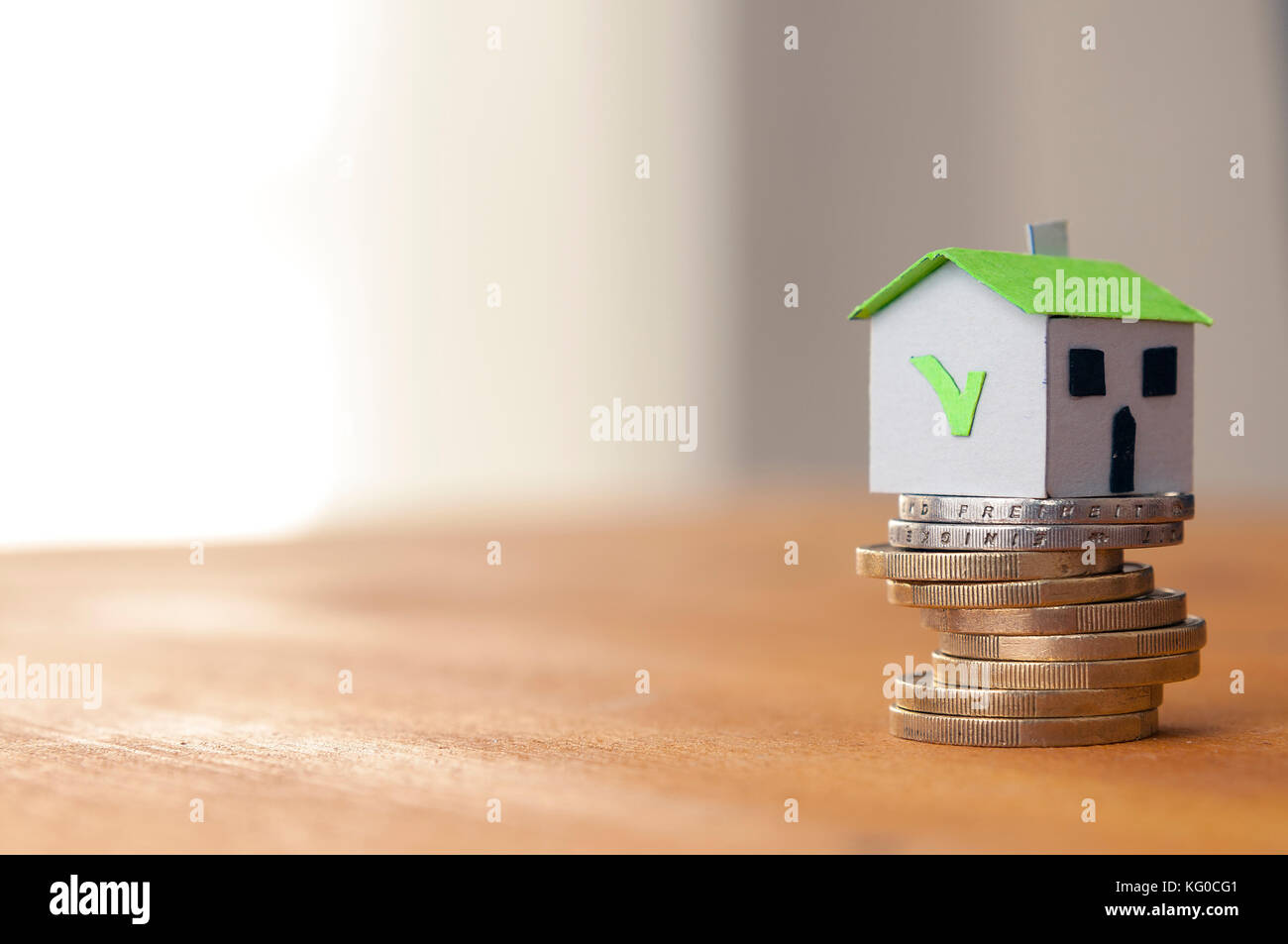 Hypotheken und Darlehen Konzept: Papier Haus auf einer Münze Stapel Stockfoto