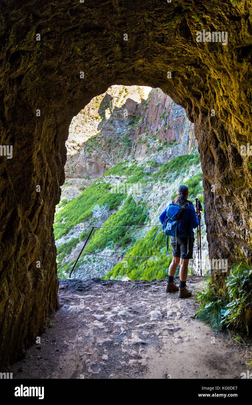 Weibliche Wanderer über einen Tunnel auf dem Weg vom Pico do Arierio zu Pico Ruivo - der höchste Berg in Madeira, Portugal Stockfoto