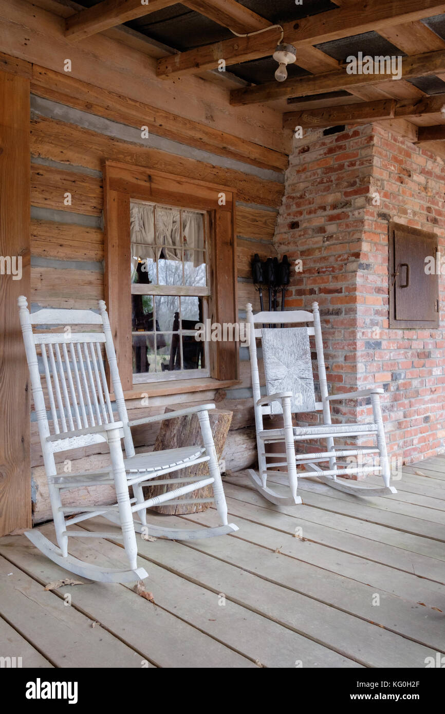 Altmodische weiße Schaukelstühle auf der Veranda eines alten Hütte in ländlichen Alabama, USA. Stockfoto