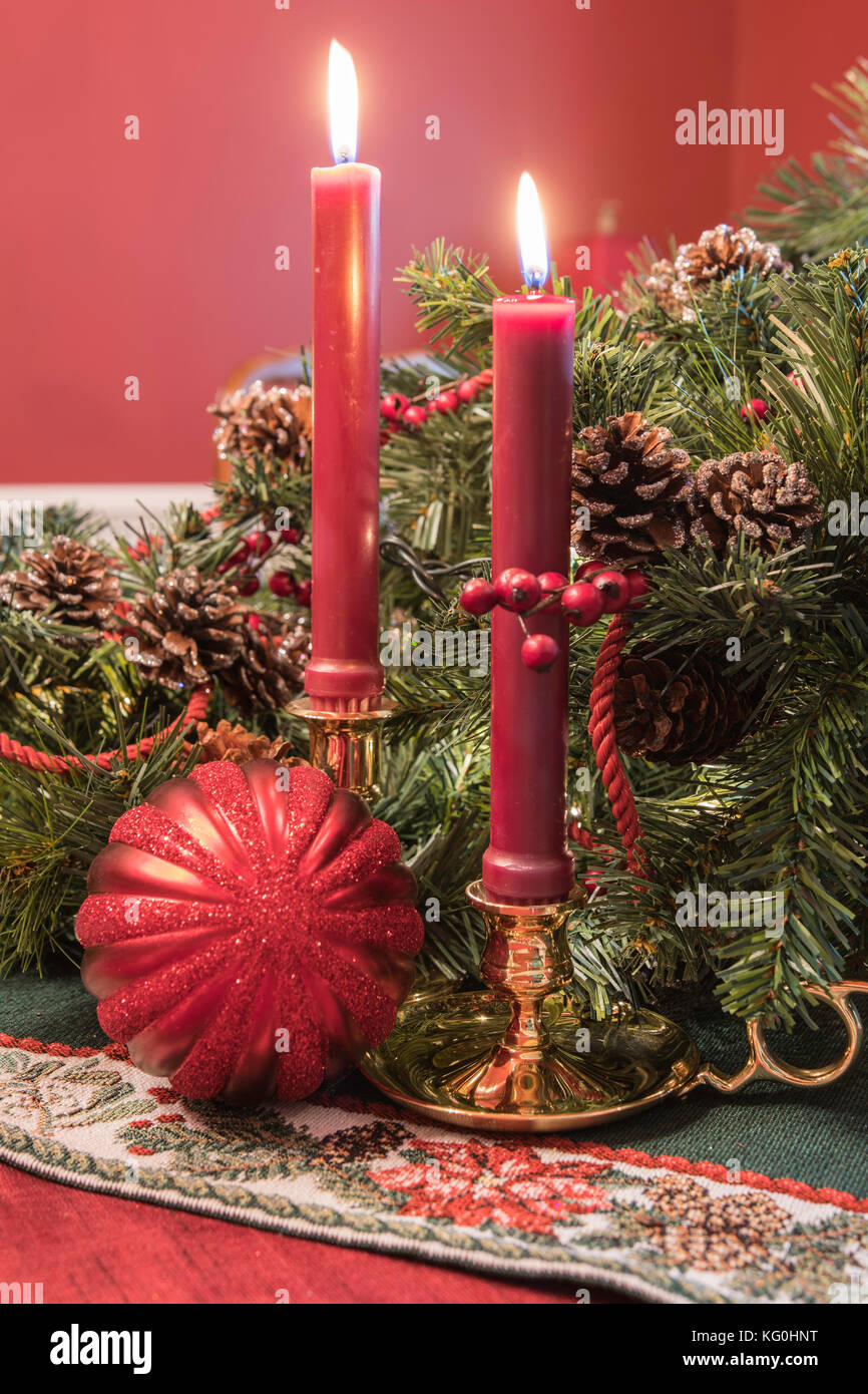 Weihnachten Anzeige mit Messing Kerzenständer, Grün, Tannenzapfen, und eine rote Kugel ornament Stockfoto