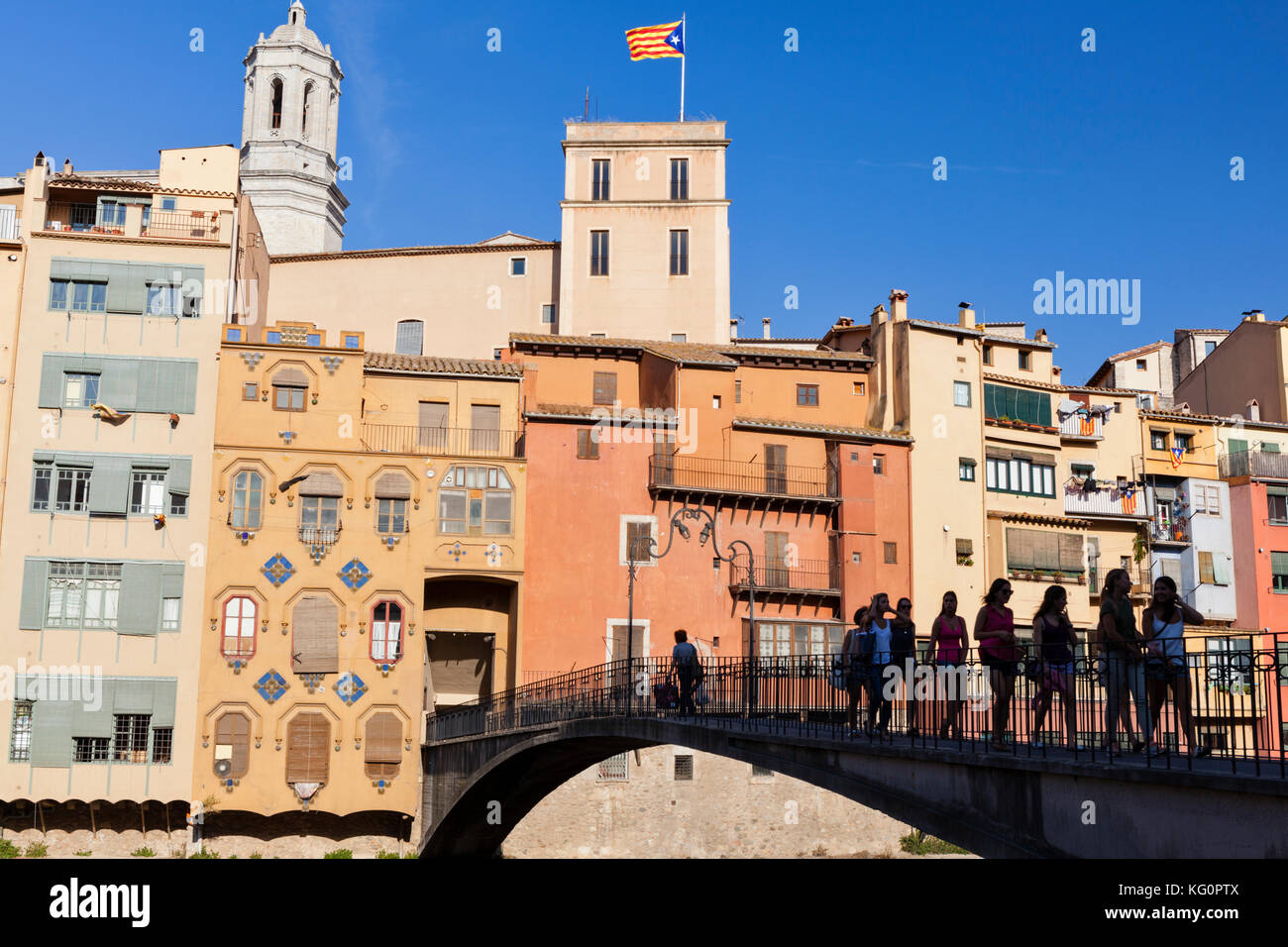 Eine Gruppe von Mädchen überqueren Sie eine Brücke über den Fluss Onyar mit dem historischen Häusern in der Altstadt von Girona, Katalonien, Spanien im Hintergrund. Stockfoto