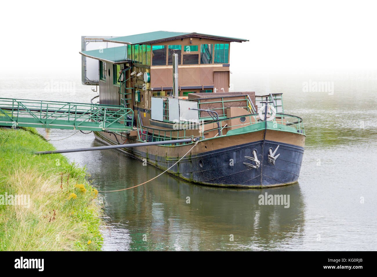 Riparian Landschaft zeigt eine Verankerung altes Haus Boot mit Brücke an der Wasseroberfläche Stockfoto