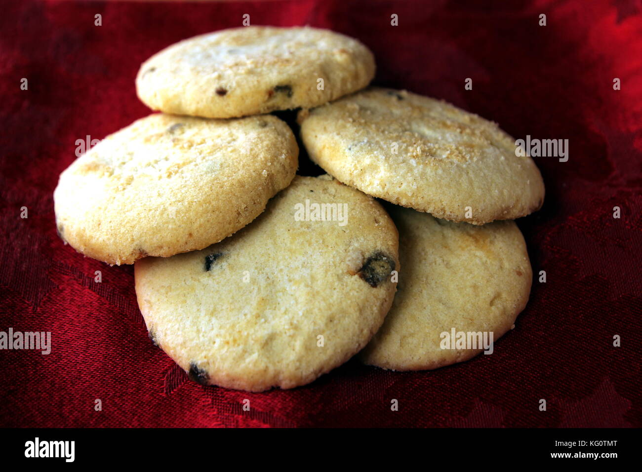 Gruppe von fünf Choc Chip und Obst Plätzchen, auf einer festlichen roten Hintergrund. Stockfoto