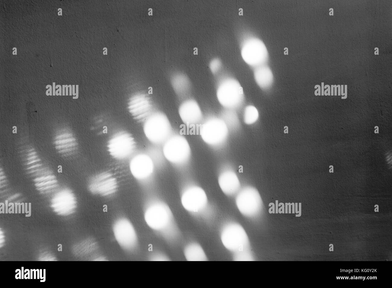 Lichtpunkte in einer Wand Bild in Schwarz und Weiß reflektiert Stockfoto