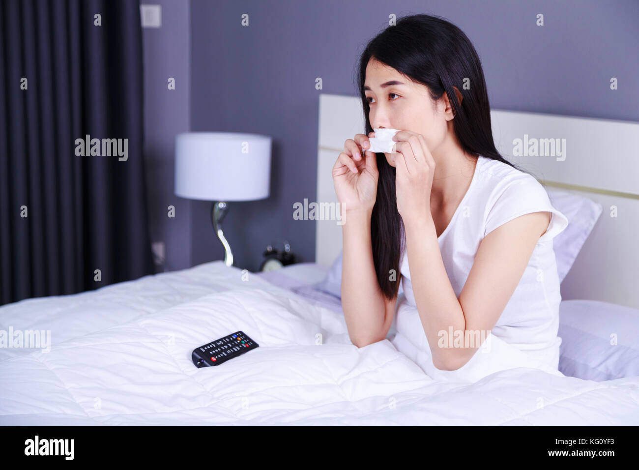 Frau Weinen Wahrend Sie Fernsehen Mit Fernbedienung Auf Dem Bett Im Schlafzimmer Stockfotografie Alamy