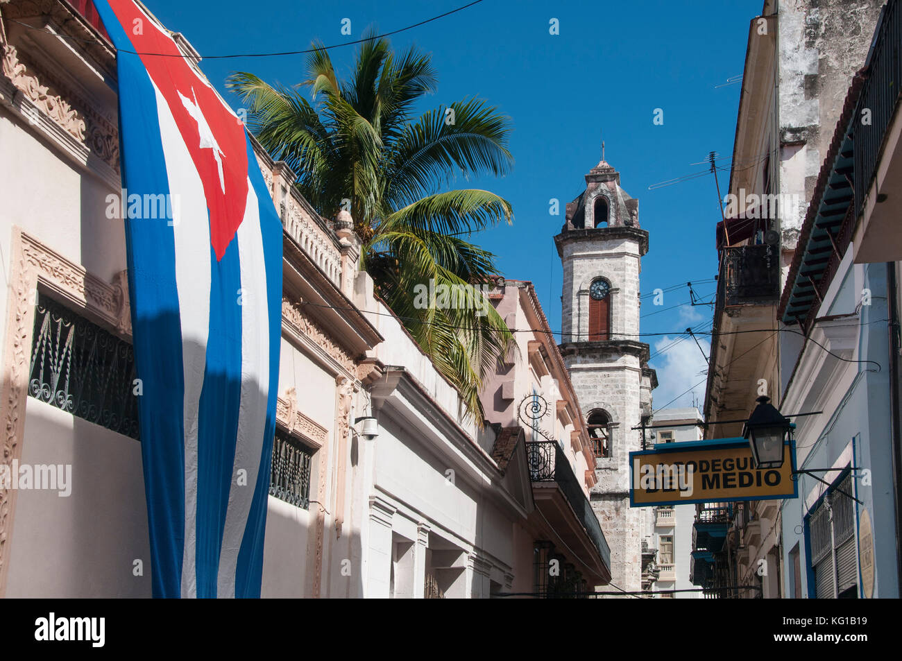 Die kubanische Flagge schmückt die Wände in der Calle Empedrado unterstützt von einem Glockenturm der Kathedrale von San Cristobal, Habana Vieja, Havanna, Kuba Stockfoto
