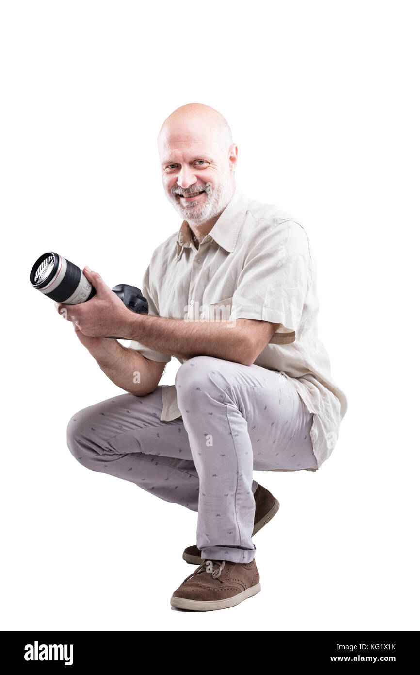 Lächelnd duckte Experte Fotograf seine Kamera hält in seinen Händen - auf weißen isoliert Stockfoto