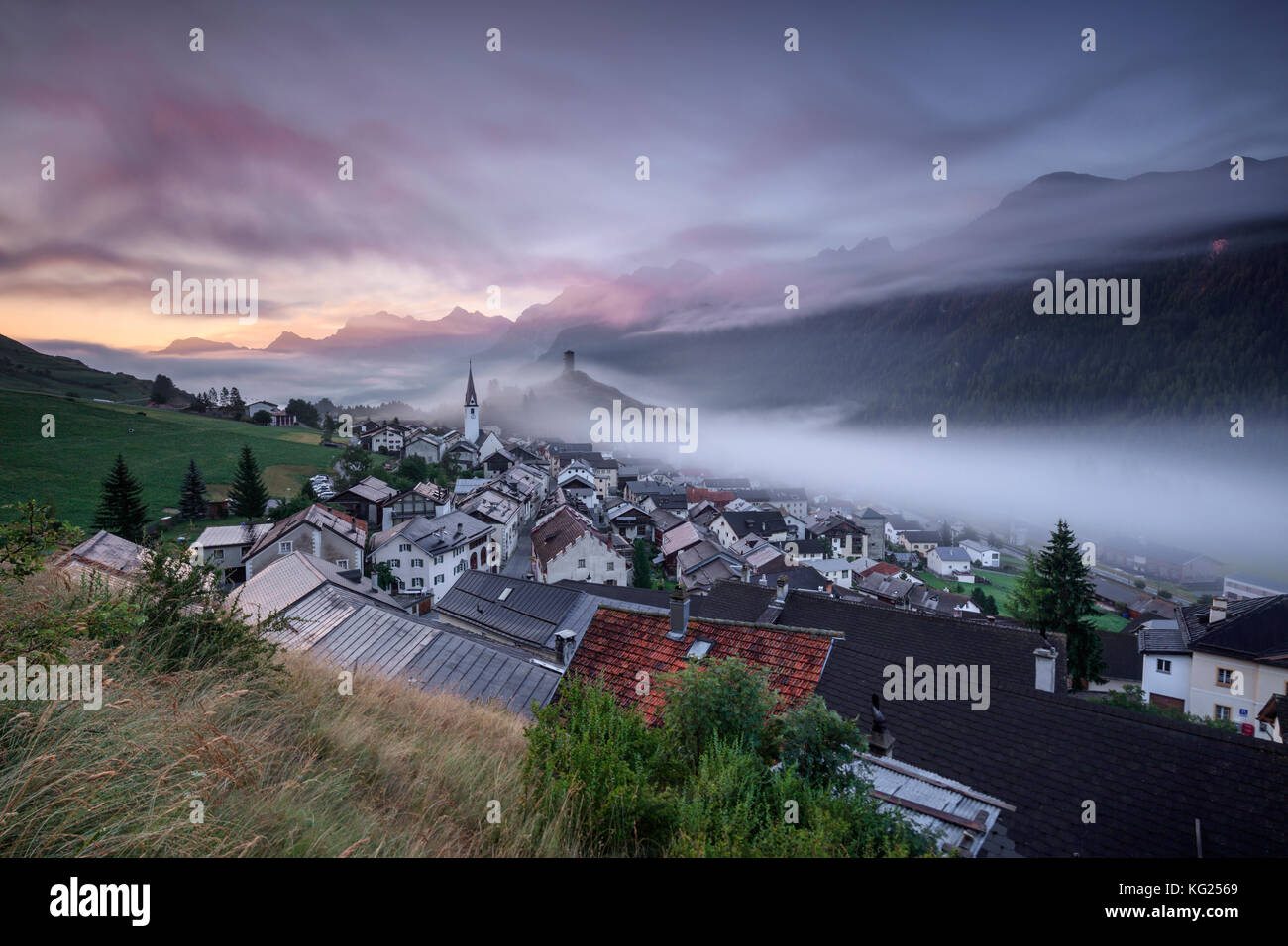 Rosa Wolken und Nebel auf dem Dorf Ardez bei Sonnenaufgang, Bezirk Inn, Unterengadin, Kanton Graubünden, Schweiz, Europa Stockfoto