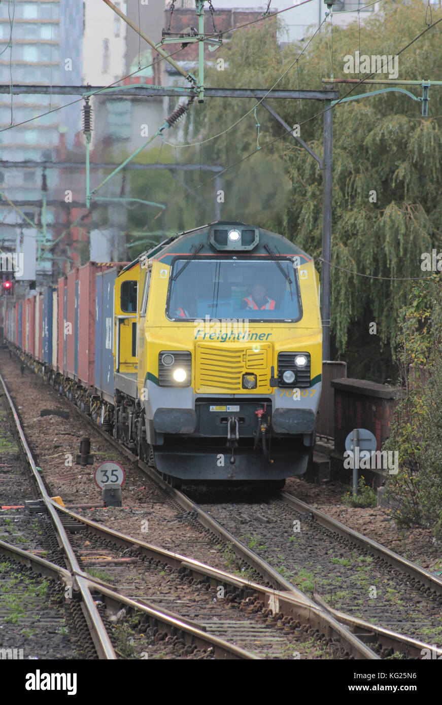 Ein Containerzug von Freightliner nähert sich dem Bahnhof Manchester Piccadilly, der mit der Diesellokomotive Nr. 70007 transportiert wird. Stockfoto