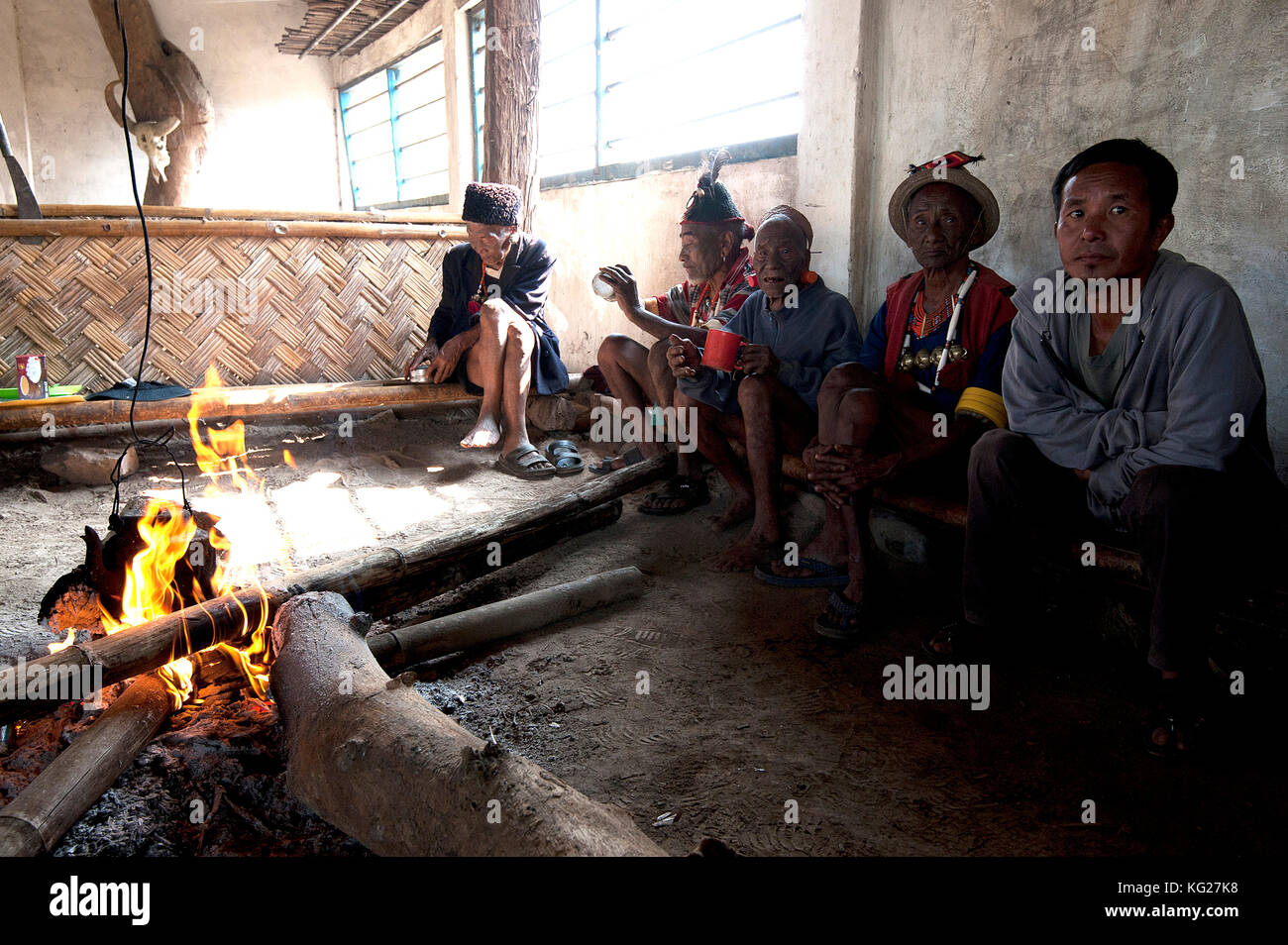 Naga Männer sitzen plaudernd runde Feuer im Dorf Muting (Saal), Nagaland, Indien, Asien Stockfoto