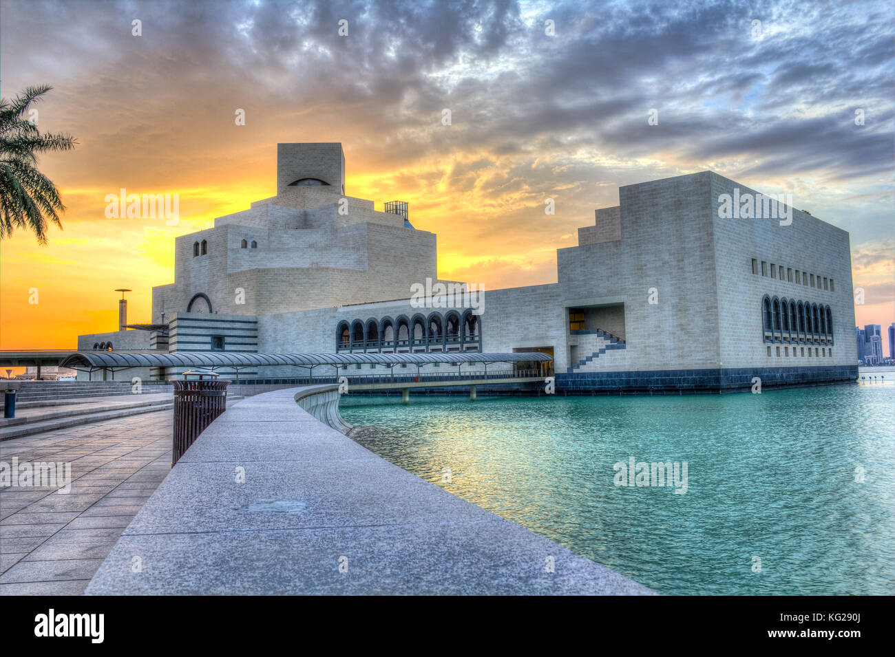 Museum für Islamische Kunst in Doha, Katar im Tageslicht Außenansicht mit Arabischen Golf im Vordergrund und Wolken im Himmel im Hintergrund Stockfoto