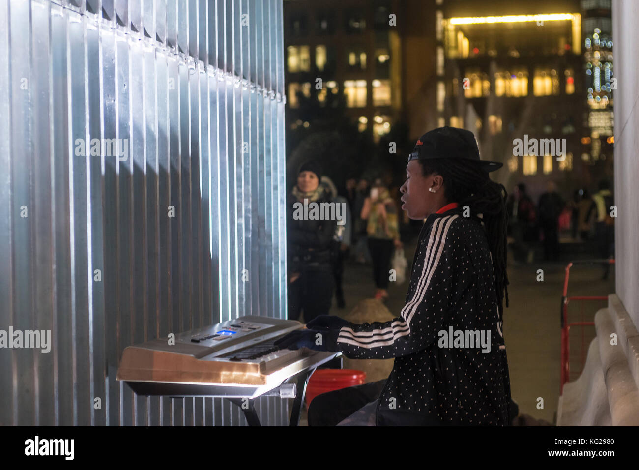 New York, NY 27. Oktober 2017 - eine Straße Interpret eingekeilt zwischen einem Bein des Washington Square arch und Ai Weiwei's Skulptur, "Gute Zäune machen gute Nachbarn" führt an einem warmen Herbst nacht Greenwich Village. © Stacy walsh Rosenstock Stockfoto
