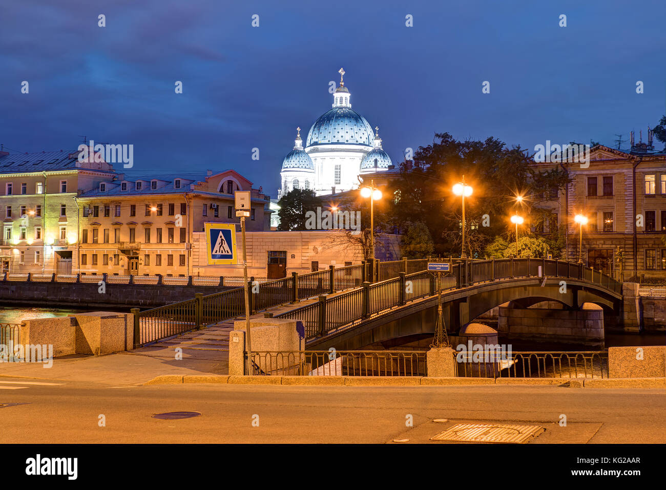 Nachtansicht des krasnoarmeysky Brücke und die Kuppel der Dreifaltigkeitskathedrale hinter Gebäude am Ufer der Fontanka, St. Petersburg, RU Stockfoto