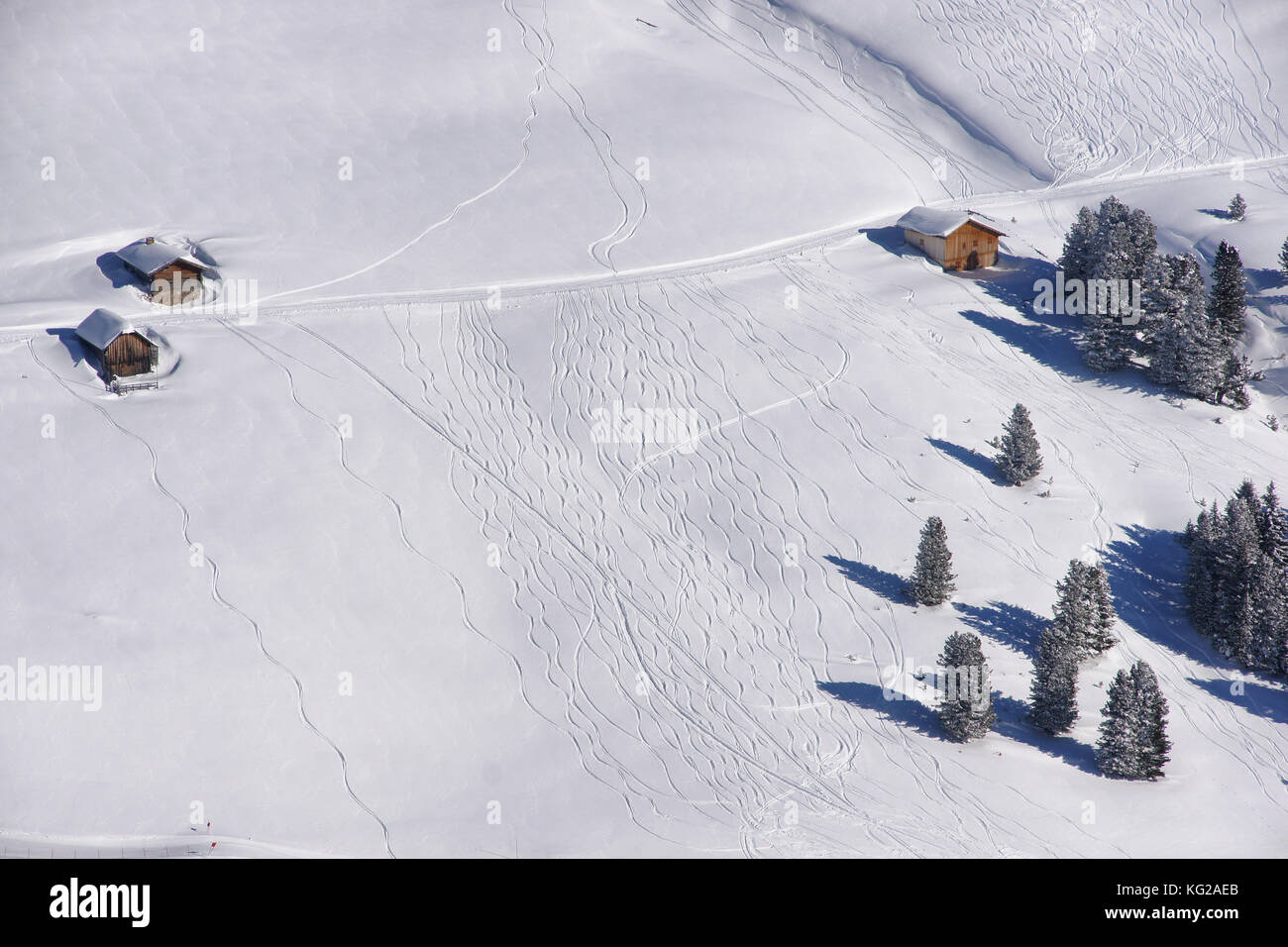 Muster in den Schnee, die Skifahrer, Snowboarder und Motorschlitten. Winterlandschaft mit Schnee bedeckt, Bäume und Hütten Stockfoto