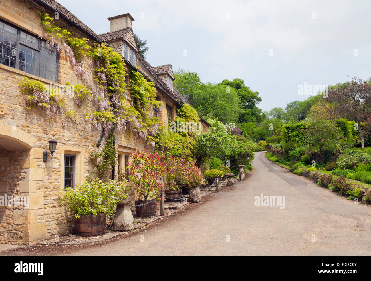 Traditionelle Häuser aus Stein, die von einem Dorf weg und Gärten, in den ländlichen Cotswolds, an einem sonnigen Sommertag. Stockfoto