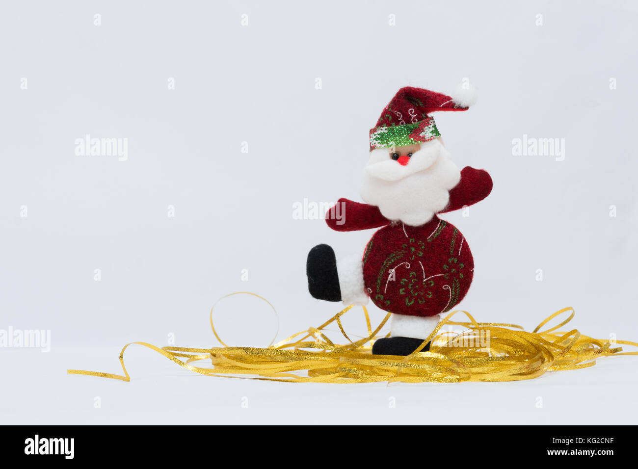 Schmückbarer roter Weihnachtsmann mit goldenem Grund und weißem Hintergrund. Stockfoto