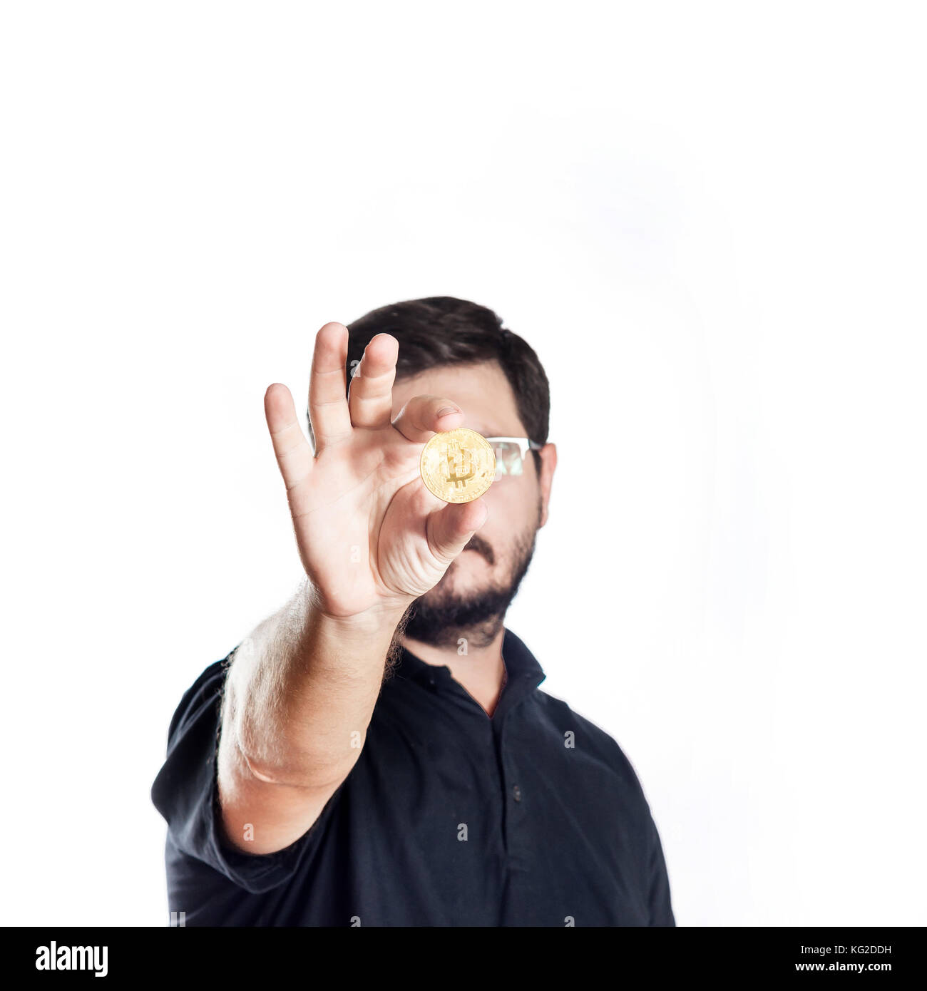 30 Jahre alt Mann hält bitcoin vor ihm selbst auf weißem Hintergrund Stockfoto