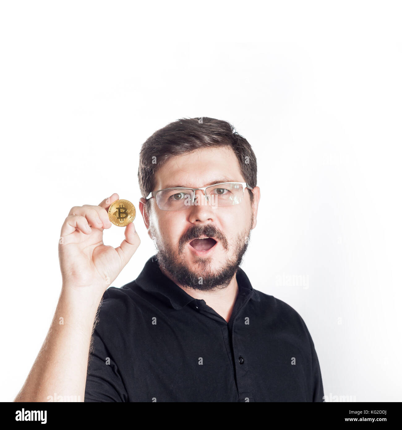 30 Jahre alt Mann hält bitcoin vor ihm selbst auf weißem Hintergrund Stockfoto