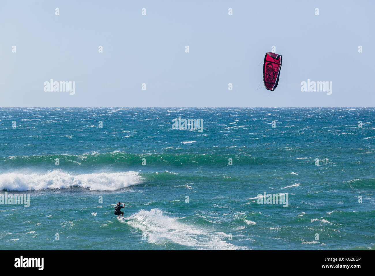 Kite Surfer Köpfe heraus in Richtung Ozean Horizont durch Wellen. Stockfoto