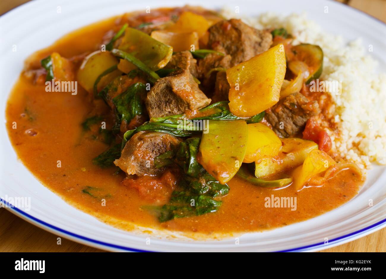 Hausgemachtes saag Gosht Rind Curry mit weißem Reis auf einem weißen Teller auf Eichentisch Stockfoto