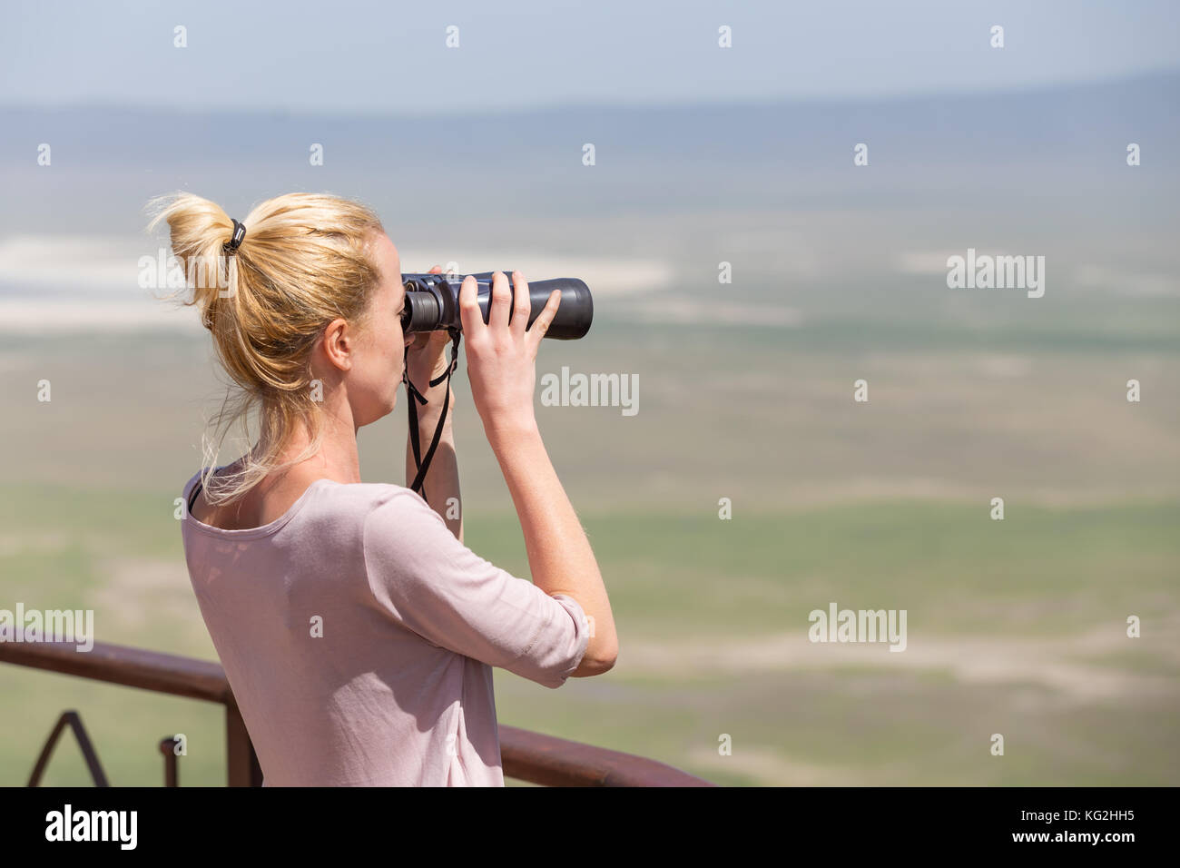 Weibliche Touristen auf der Suche durch ein Fernglas auf Safari im Ngorongoro Krater consrvation, Tansania, Afrika. Stockfoto