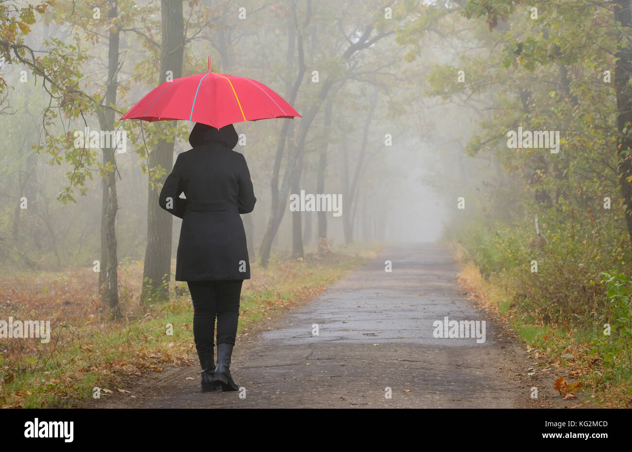 Deprimiert Frau mit roten Dach und nebligen Wald Stockfoto