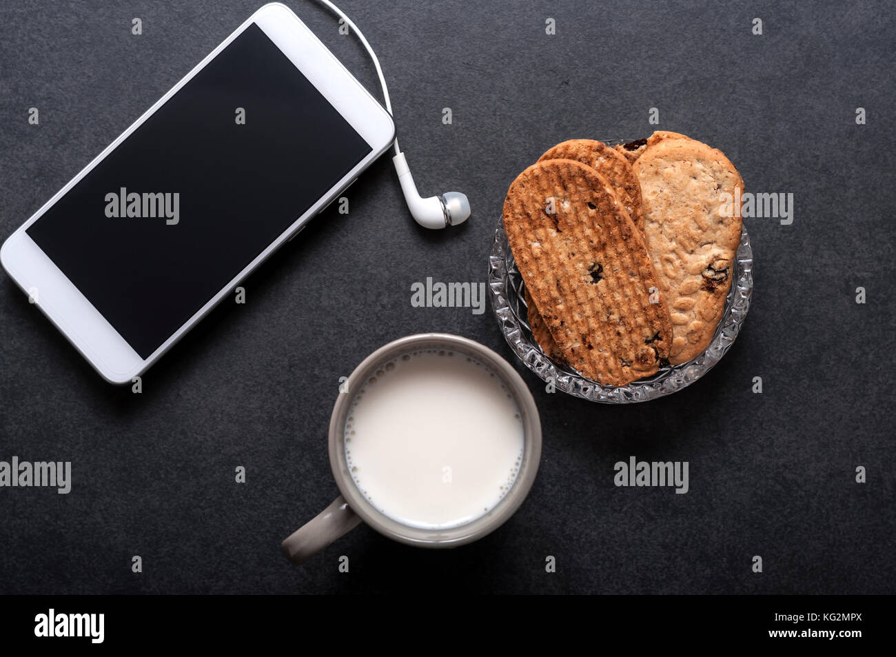 Haferflocken Rosinen Cookies, Milch und das Telefon auf den Tisch Stockfoto