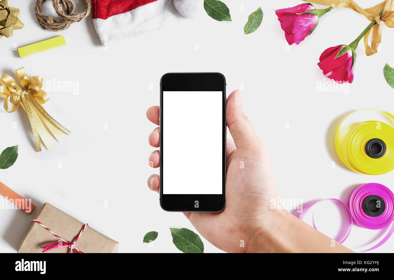 Hand, Smart Phone, leeren weißen vertikalen Bildschirm auf weißem Hintergrund mit Weihnachten und Valentinstag Dekoration Stockfoto