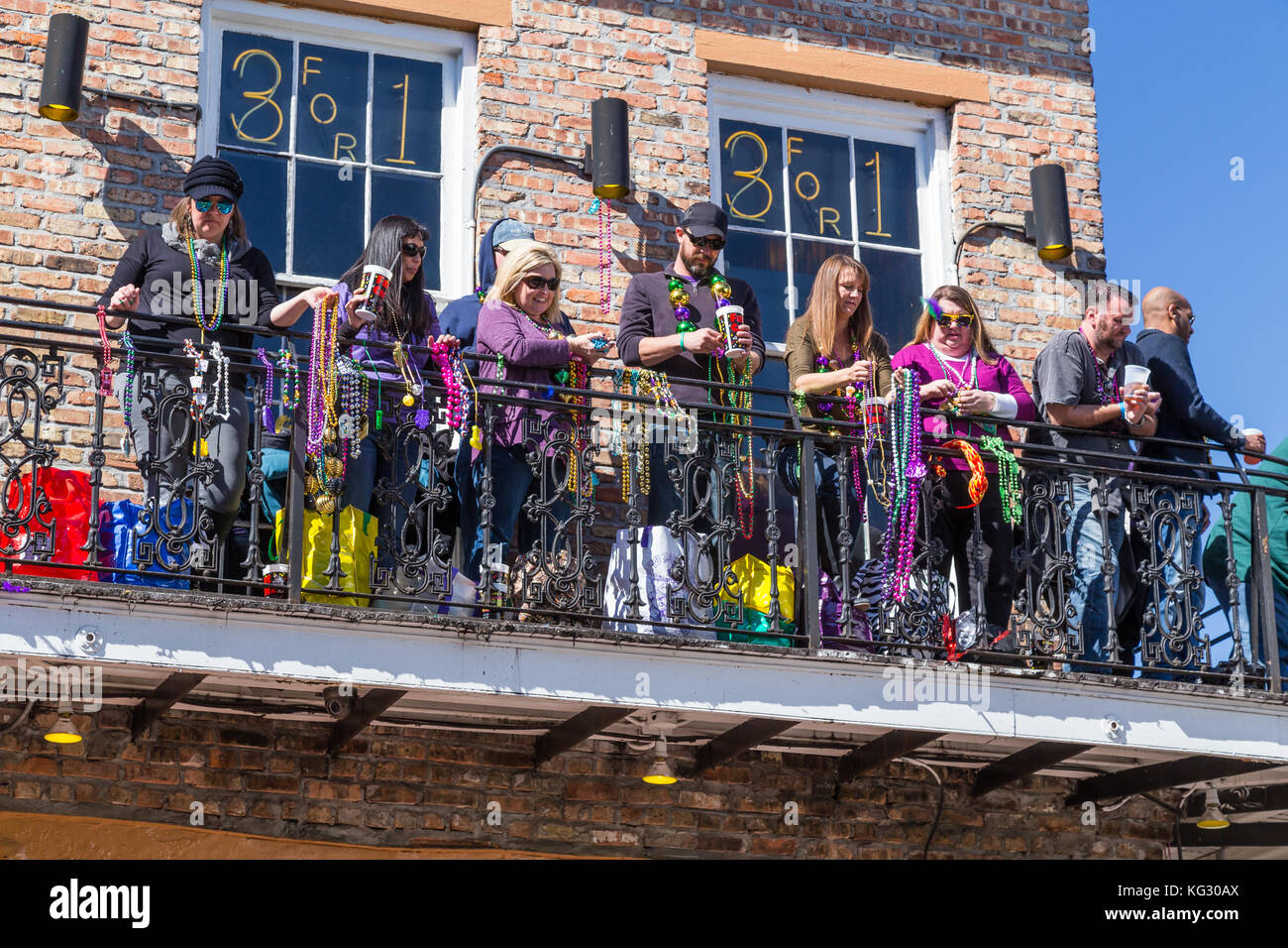 Die Menschen werfen Perlen von Balkonen während Mardi Gras in New Orleans, Louisiana Stockfoto