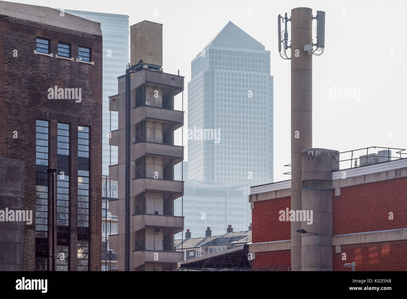 London, UK, 24. Oktober 2017 - Wolkenkratzer in Canary Wharf durch alte Industrie Gebäude in Pappel, East London gesehen Stockfoto