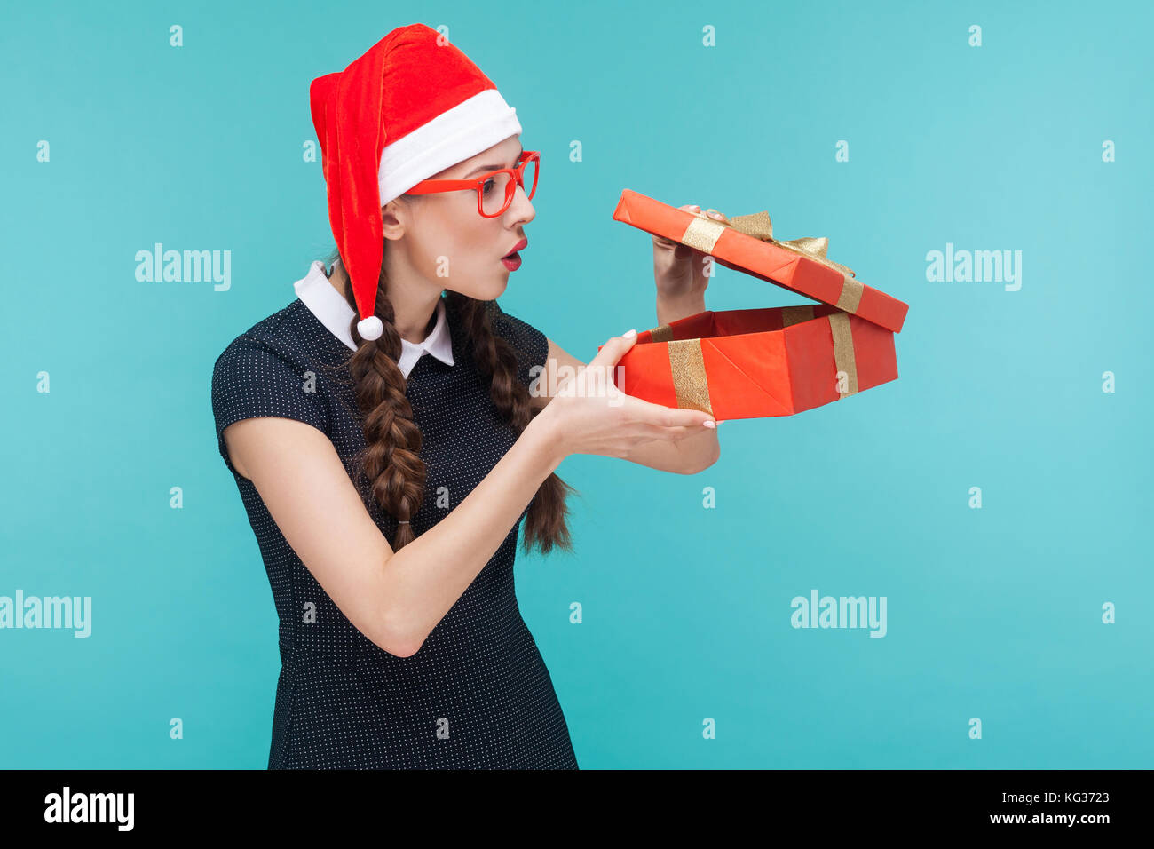 Gerissen Geschäftsfrau in Geschenkbox und wollen zu öffnen. blauen Hintergrund. studio Shot Stockfoto