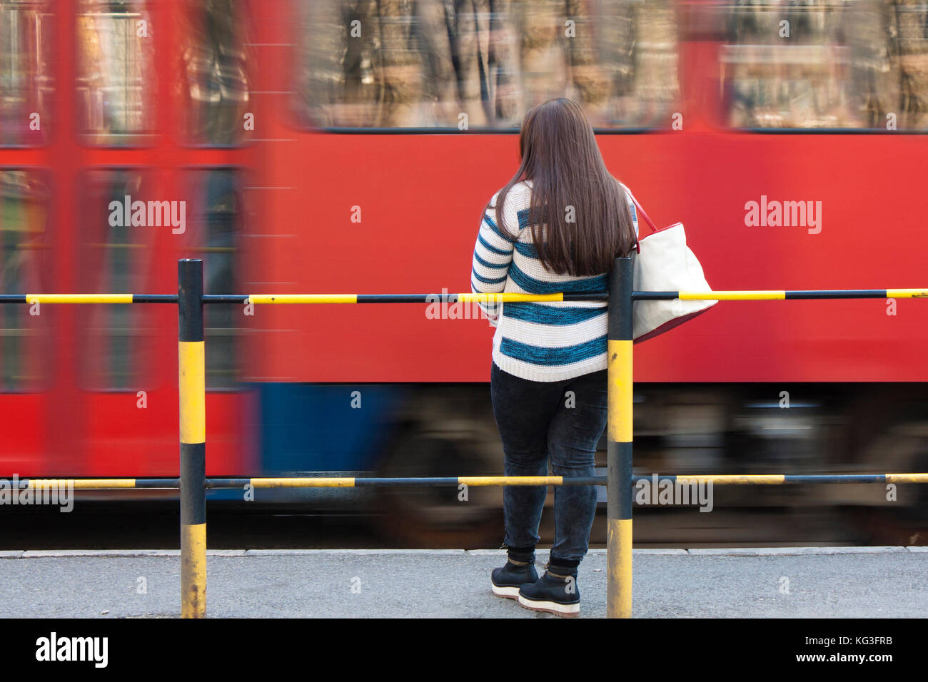 Belgrad, Serbien - 21. März 2017: Eine junge Frau - teenage Mädchen an Bus- und Straßenbahn-Haltestelle und Stadtverkehr in motion blur warten Stockfoto