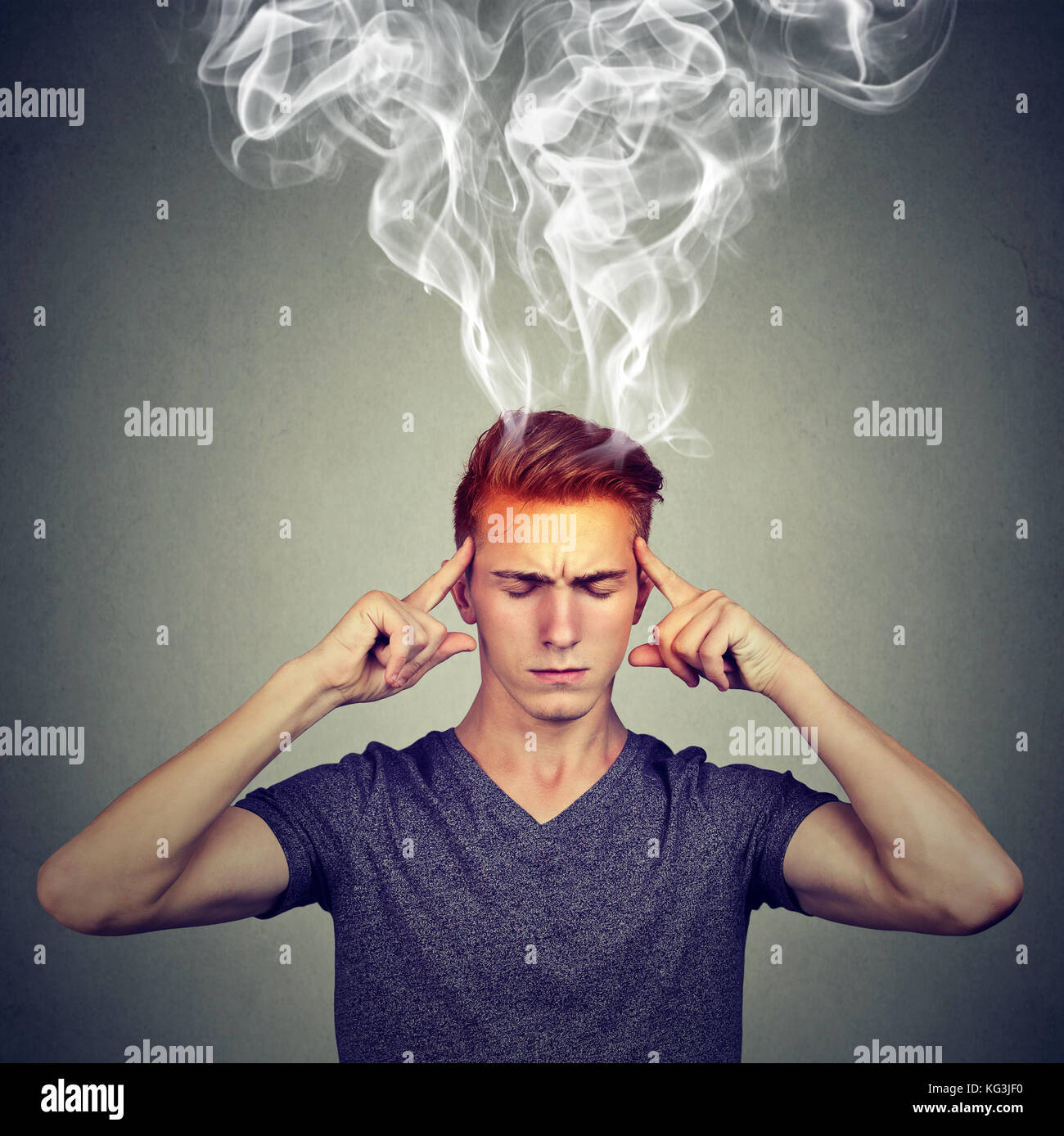 Mann denkt sehr intensiv mit Kopfschmerzen auf graue Wand Hintergrund isoliert Stockfoto