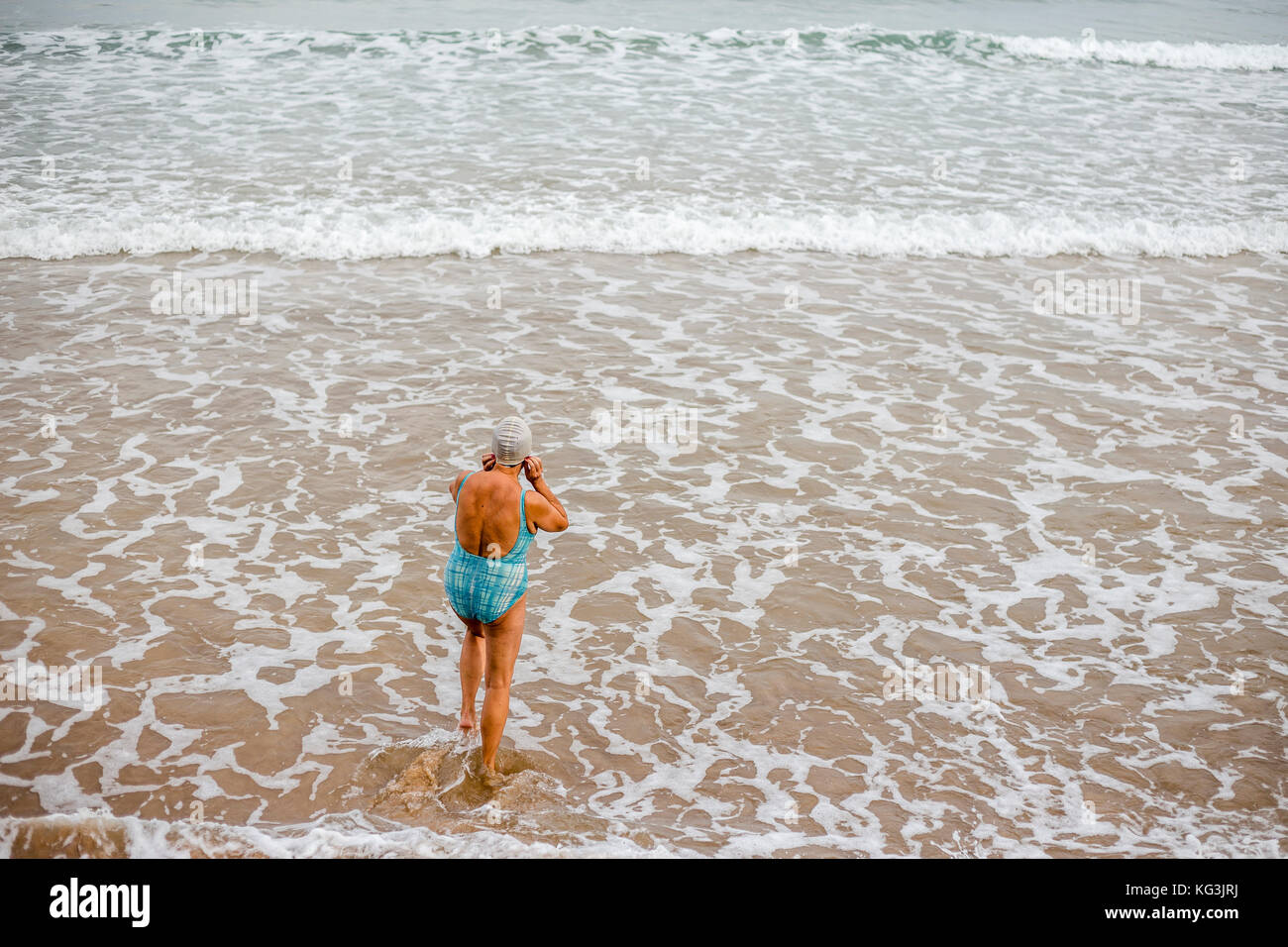 Ältere Frau, die im Meer schwimmt - Gijón, Asturien Spanien Stockfoto