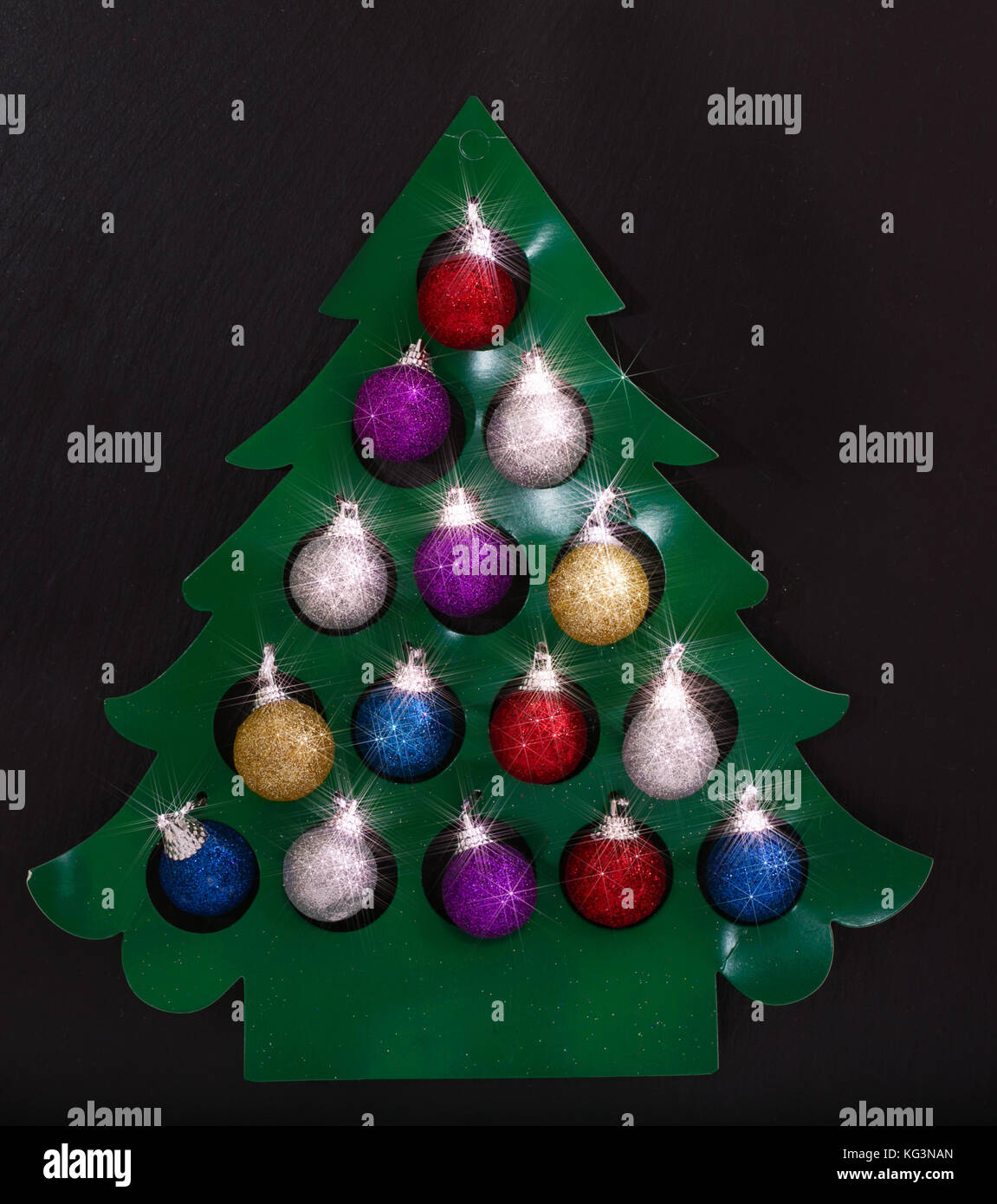 Tannenbaum aus Papier mit bunten Kugeln. einen schwarzen Hintergrund